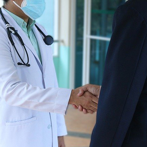 Doctor shaking hands with client